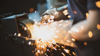 Grinding,Steel,With,Lot,Of,Sparks,By,Worker,In,Factory